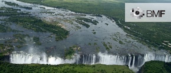 An aerial image of a huge river flowing out into white, vertiginous waterfalls.